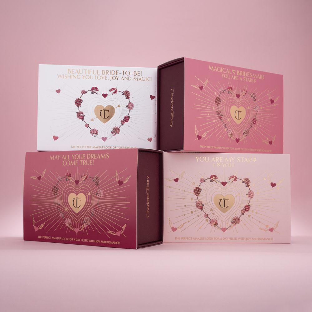 Banner with four, makeup sleeves in shades of pink and white with hearts printed on them and the CT logo printed in gold colour in the middle.