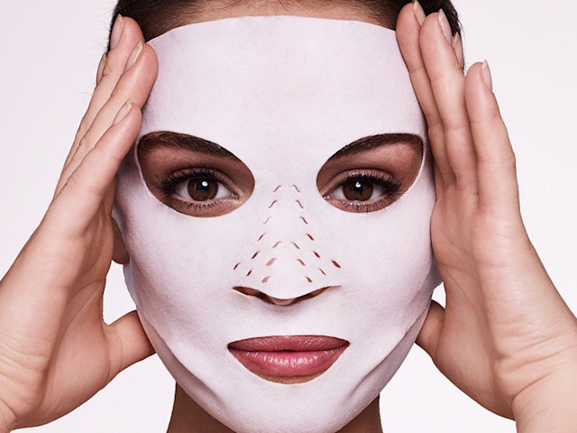 Close-up of a model with brown eyes wearing a textured fabric face mask. 