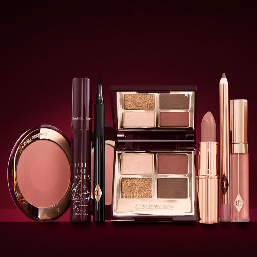 An open, mirrored-lid eyeshadow palette in matte and shimmery brown and gold shades, an open black eyeliner pen, a mascara in a dark-crimson colour scheme, a berry-rose lipstick with a matching lip liner pencil, nude pink lip gloss, and an open two-tone blush in warm pink. 