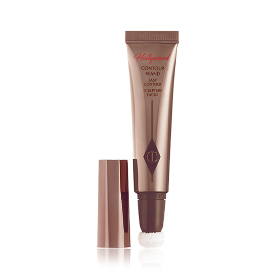 An open, creamy contour wand in dark bronze-coloured packaging with the lid next to the tube. 