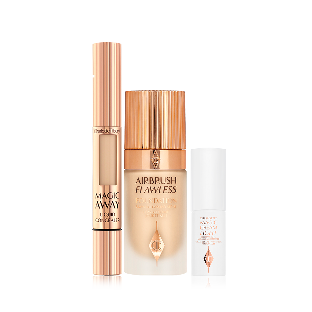 Creamy liquid concealer in a gold-coloured tube with a soft sponge applicator end, foundation in a frosted glass bottle with a gold-coloured lid, and pearly-white face cream in a glass jar with a gold coloured lid.