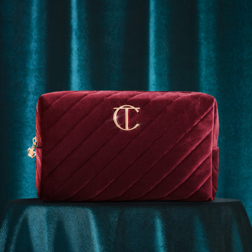 Red velvet makeup bag with the CT logo on the top in golden colour.
