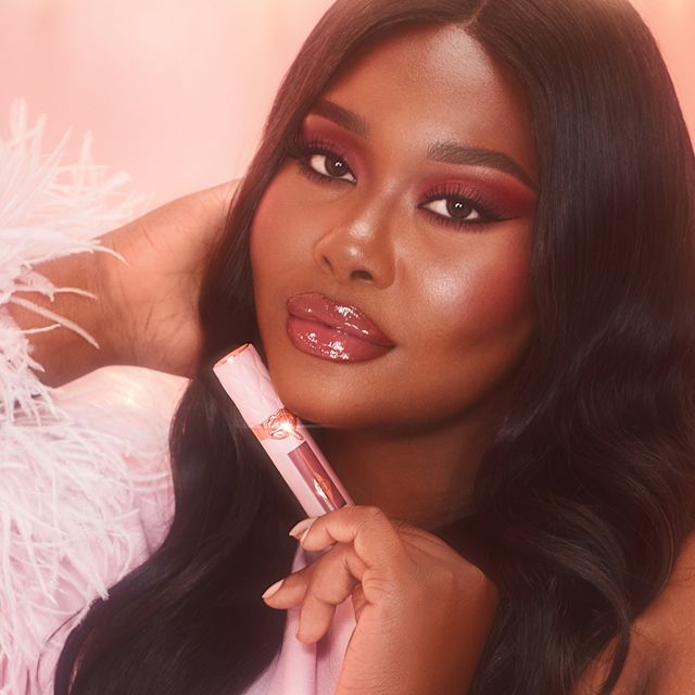 Model wearing Pillow Talk Plumpgasm lip gloss- for plumper-looking glossy lips