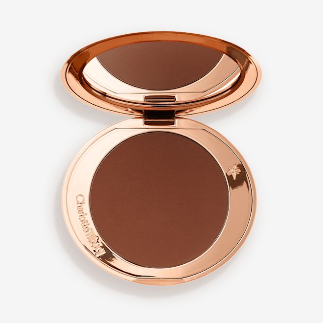Airbrush Bronzer in Deep open An open mirrored-lid bronzer compact in a dark brown shade.
