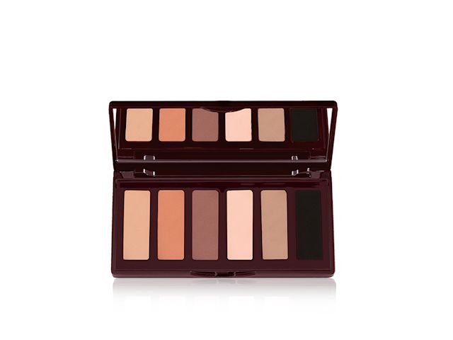 An open, mirrored-lid six-pan eyeshadow palette with matte eyeshadows in brown, peach, and beige shades.