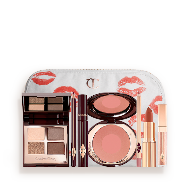 The Golden Goddess kit for Fair, Light and Medium tones displayed An open, mirrored-lid eyeshadow palette in matte and shimmery gold, brown, and beige shades, an open black eyeliner pencil, a mascara in a dark-crimson colour scheme, a golden-peach lipstick with a nude pink lip liner pencil, nude-peach lip gloss, and an open two-tone blush in muted brown-pink.