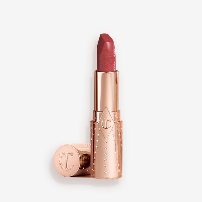 K.I.S.S.I.N.G en Rosy Seduction sin tapa Una barra de labios abierta de acabado satinado en un tono rosa con tubo dorado y la tapa al lado.