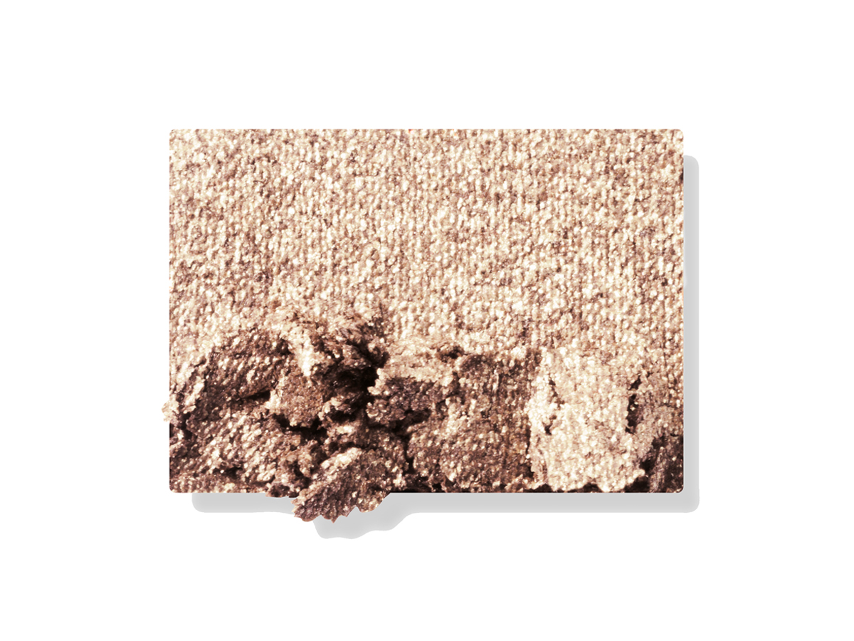 Swatch of a shimmery powder eyeshadow in a champagne-gold shade. 