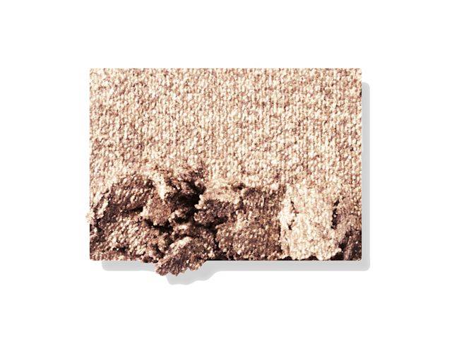 Swatch of a shimmery powder eyeshadow in a champagne-gold shade. 