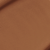 Close-up swatch of a skin-like, glowy foundation in a black-brown shade.