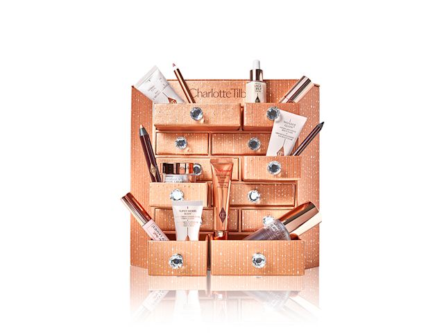 A dresser with different products displayed, such as luminous serum, blush highlighter wands, mascaras, eyeliner pencils, eyeshadow sticks, and face creams. 