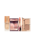 Foundation in a glass bottle with gold-coloured lid, open mirrored-lid quad eyeshadow palette with an open, nude peach lipstick in a funky tube with a panther on it, and duo contour palette with a mirrored-lid. 