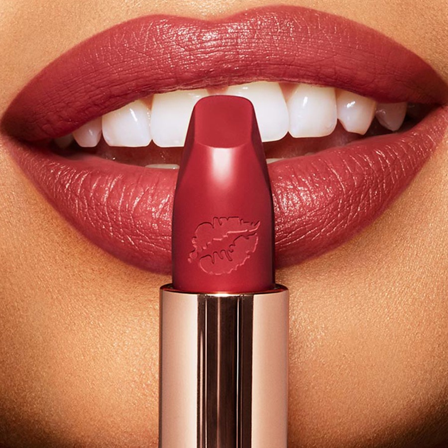 Lips close-up of a light-tone model wearing a wine red lipstick that makes her teeth appear whiter.  