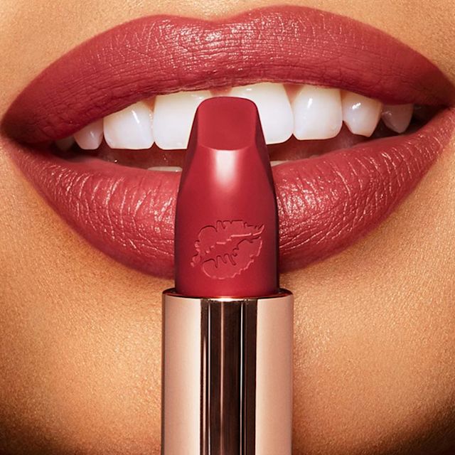 Lips close-up of a light-tone model wearing a wine red lipstick that makes her teeth appear whiter.  