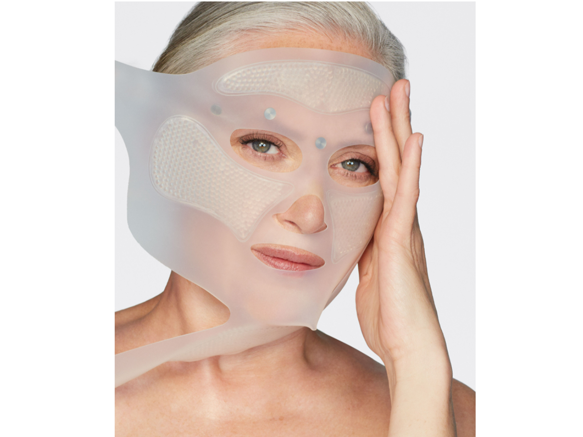 Fair-tone model with mature skin applying a reusable, white-coloured mask, that ensures glowy, flawless, and lifted skin. 