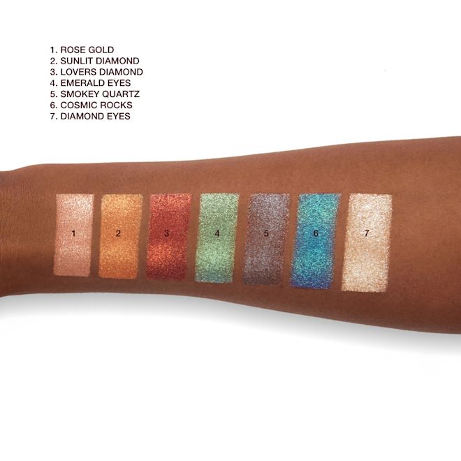 Hypnotising Pop Shots swatches on deep-tone arm Deep-tone arm with swatches of seven metallic eyeshadows in rose gold, bronze-orange, vibrant red, mint green, lilac-grey, sapphire blue, and opal.