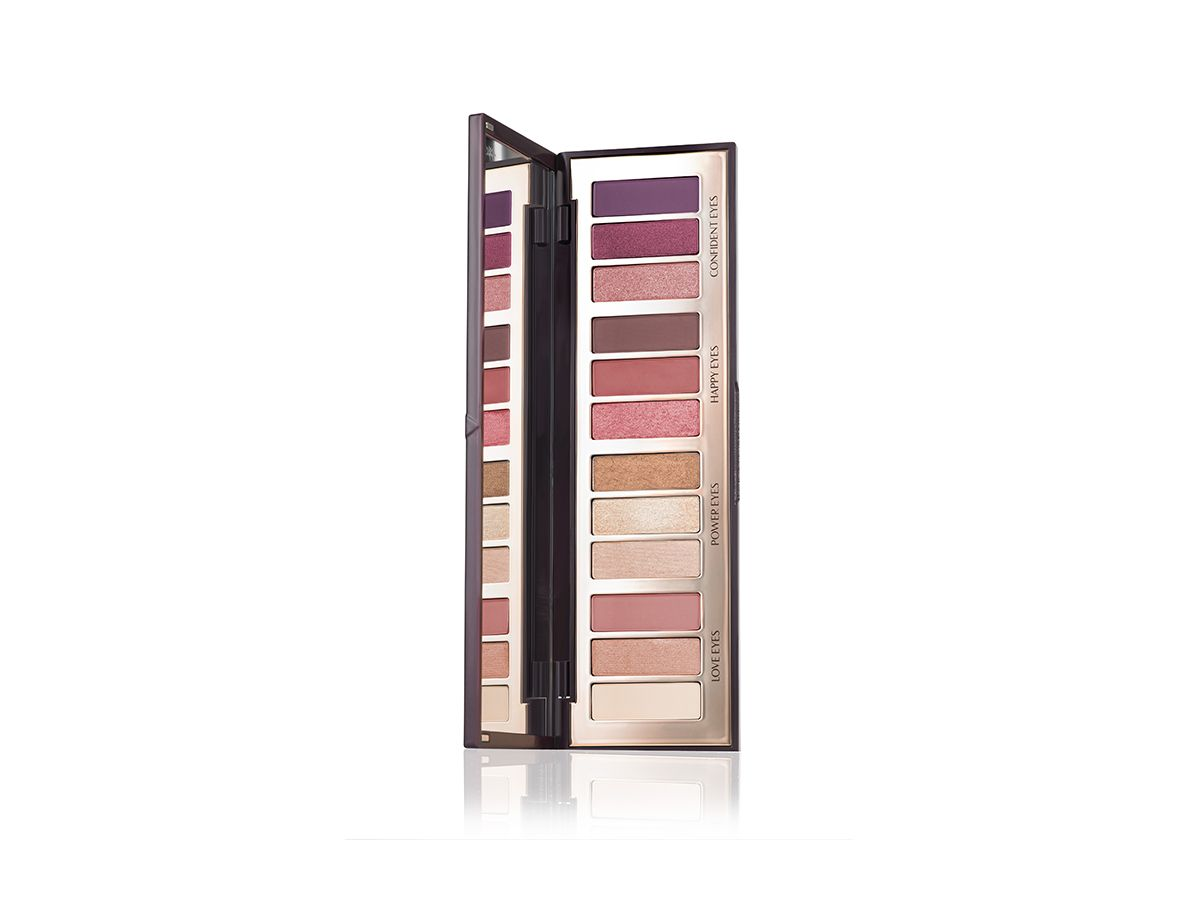 An open, mirrored-lid eyeshadow palette in matte and shimmery brown, pink, gold, purple, and nude shades. 