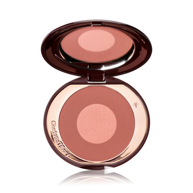 An open, two-tone, round blush with a pinky-brown outer circle and rose gold centre, encased in a metallic, rose gold case with a mirror inside the lid. 