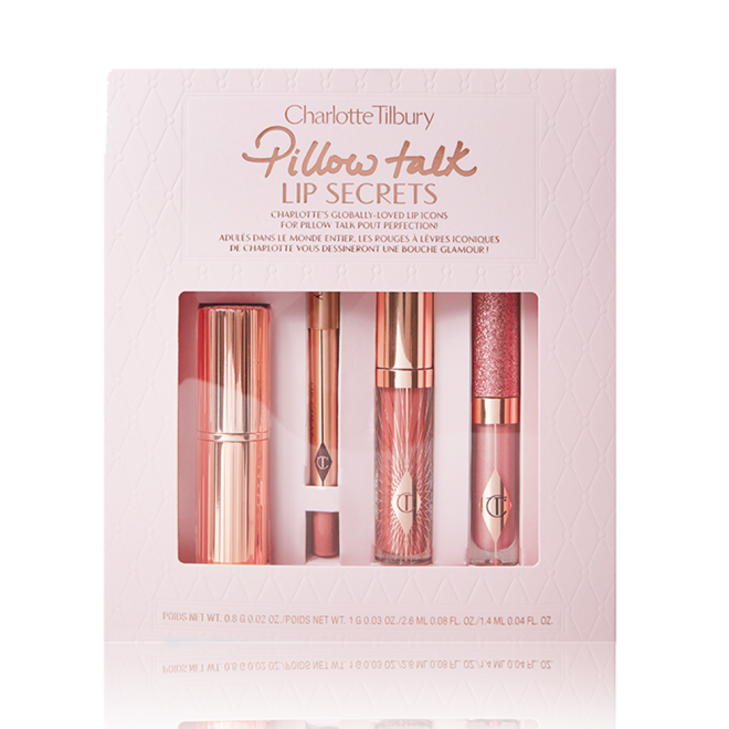 Lipstick in gold packaging, nude pink lip liner, nude pink glitter-free lip gloss, and glittery nude pink lip gloss packed in a nude pink box with Pillow Talk Lip Scerets written on it. 