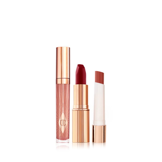 Nude pink lip gloss in a glass tube with a gold-coloured lid, blood-red matte lipstick in a gold-coloured tube, and lipstick lip balm in a soft tawny-red colour.