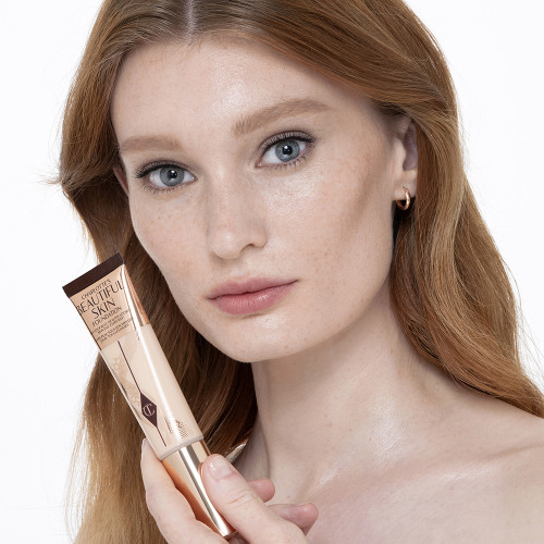 Fair-tone model with glowy, flawless skin, wearing skin-like foundation that adds a youthful glow and looks natural along with nude pink lipstick and subtle everyday eye makeup.