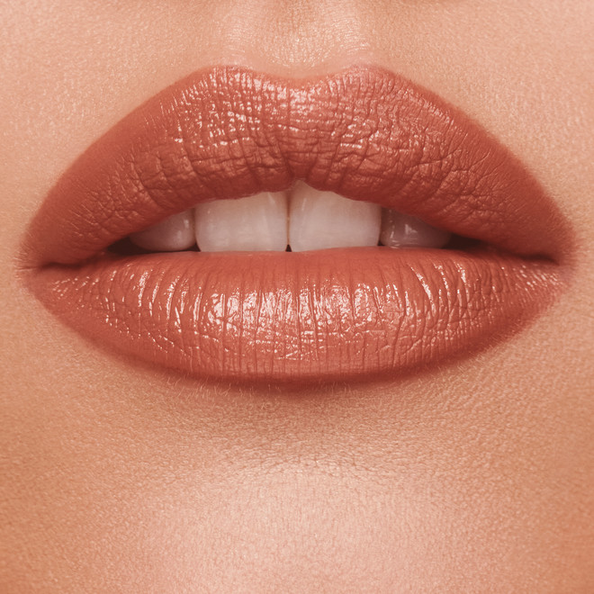 Lips close-up of a light-tone model wearing a rosy terracotta coral lipstick with a satin-finish.