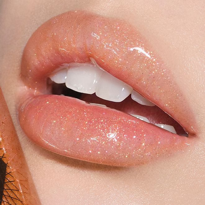 Collagen Lip Bath in Gold on fair-tone model lips close-up Lips close-up of a fair-tone model wearing sheer gold lip gloss with a high-shine finish.