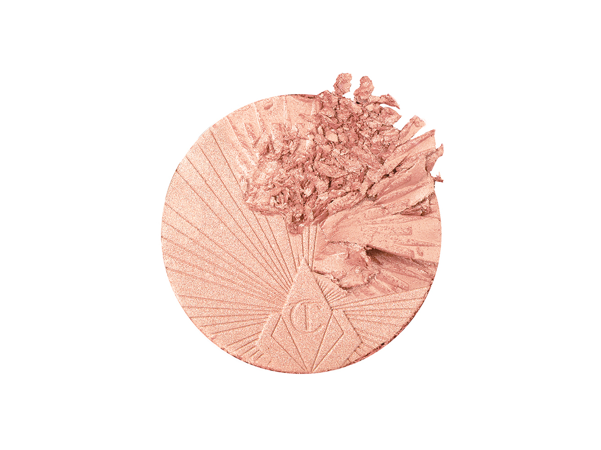 Swatch of a glowy powder highlighter in a light pinky beige shade.