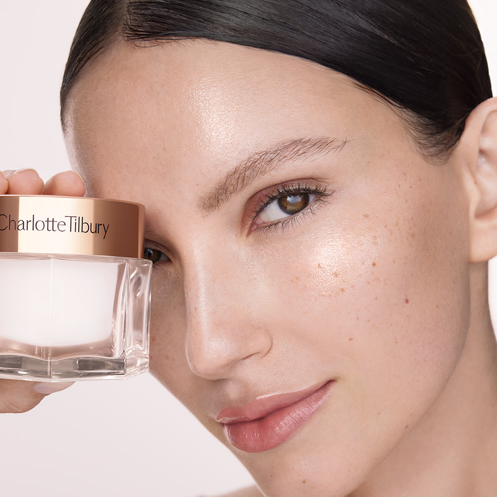 Model holding Charlotte's secret to smoother-looking skin Charlotte's Magic Cream
