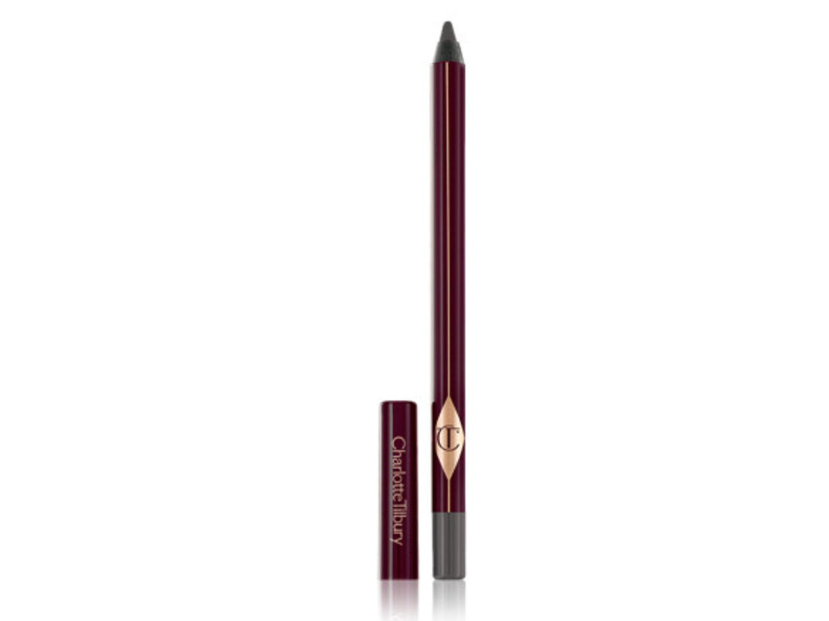 A kohl pencil in a smokey grey shade with its lid next to it.