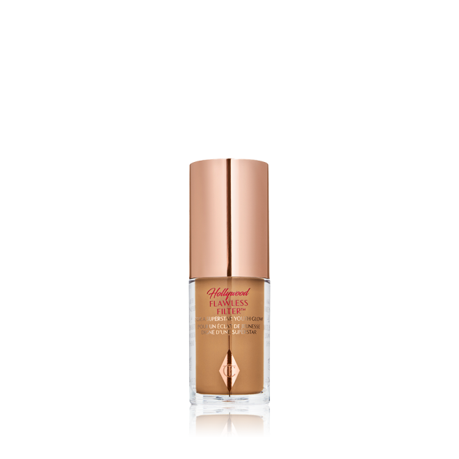 A mini luminous primer in a medium-dark shade in a glass bottle with a gold-coloured lid. 