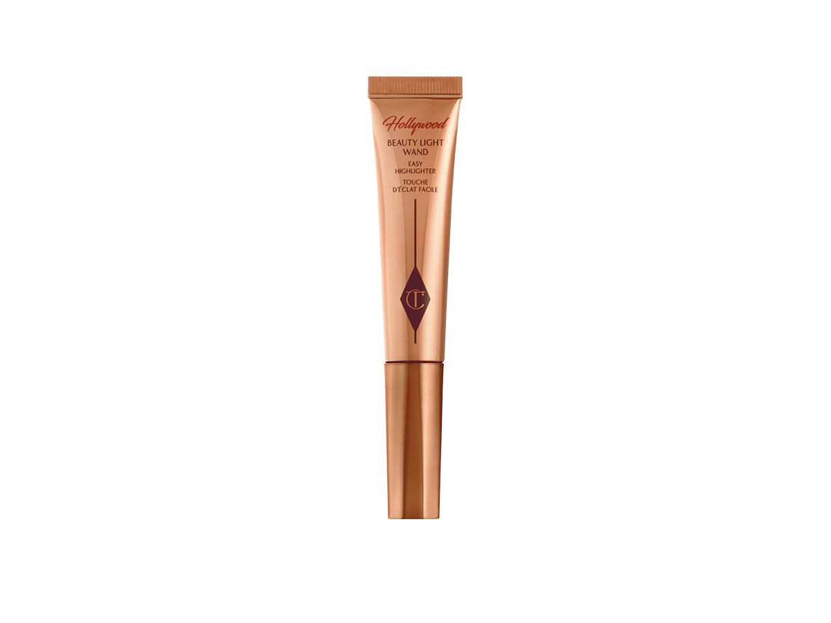 A liquid highlighter wand in a dreamy candlelight-gold shade with a brownish-copper-coloured tube.