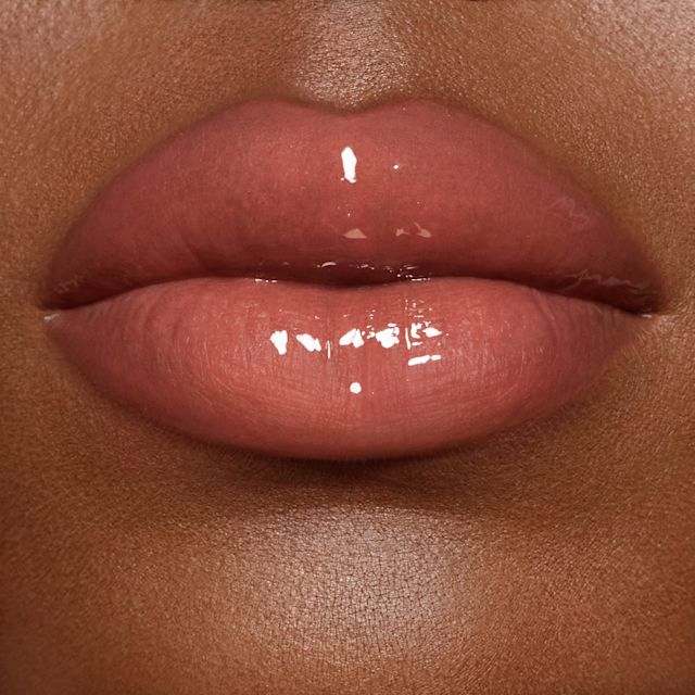 Lip close up of model wearing Pillow Talk Big Lip Plumpgasm plumping lip gloss in fair/medium