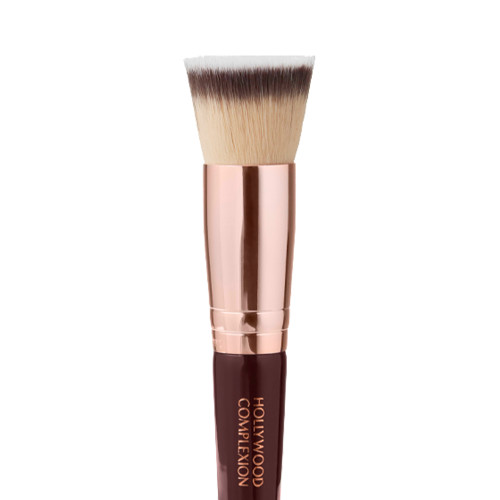 Close-up of a face blending brush with fawn, dark brown, and white-coloured bristles with rose-gold and dark crimson handle. 