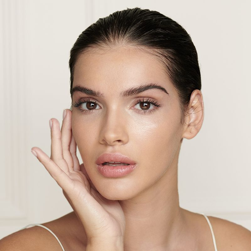 A light-tone brunette model with flawless and dewy glass skin. 