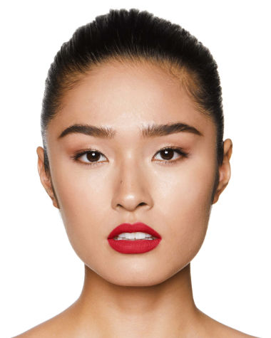 A fair-tone model with brown eyes wearing a matte, bright, cherry-red lipstick.