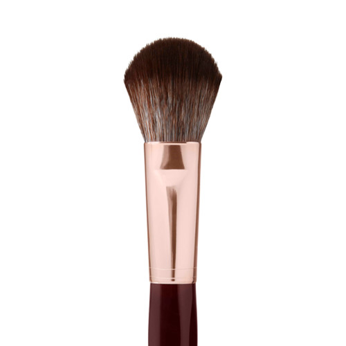 Close-up of a bronzer and blush brush with dark brown and grey bristles with a rose-gold and dark crimson handle. 