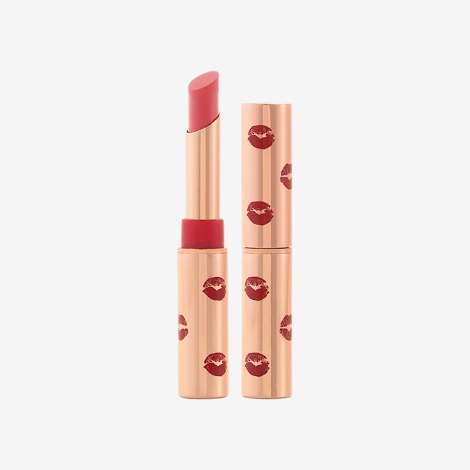 Limitless Lucky Lips in Rose Hope with and without lid Two identical lipsticks, with and without lid, in a neutral rosy-pink colour with a matte finish, in gold-coloured tubes with red-coloured kiss print all over the tube.