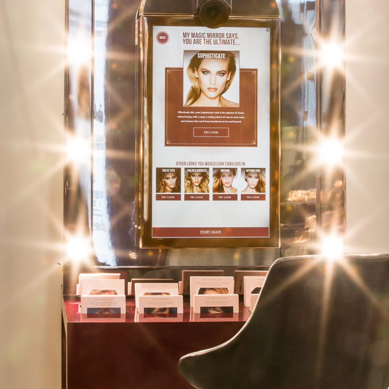An extremely bright LED mirror with table and chair in a Charlotte Tilbury store.