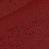 Close-up swatch of a matte lipstick in a cherry ruby red shade.