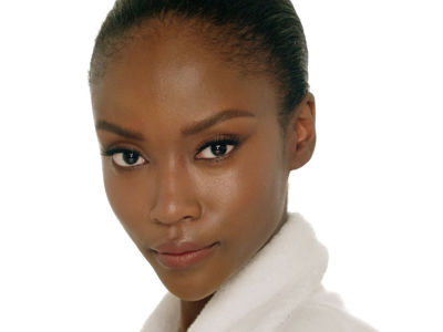 Close-up of a deep-tone model with flawless, dewy skin, sporting a no-make-up make-up look. 