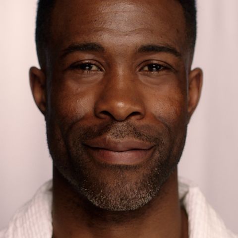 A deep-tone, brunette male model with mature, smooth, and glowing skin wearing skincare products to maintain skin's condition.