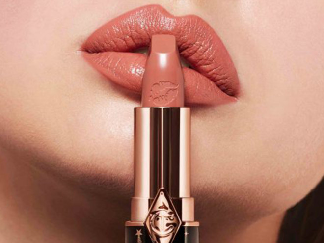 Das Model trägt den Lippenstift Hot Lips 2 in der Farbe JK Magic, einem Nude-Rosa, das heller Haut schmeichelt.