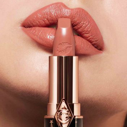 Das Model trägt den Lippenstift Hot Lips 2 in der Farbe JK Magic, einem Nude-Rosa, das heller Haut schmeichelt.