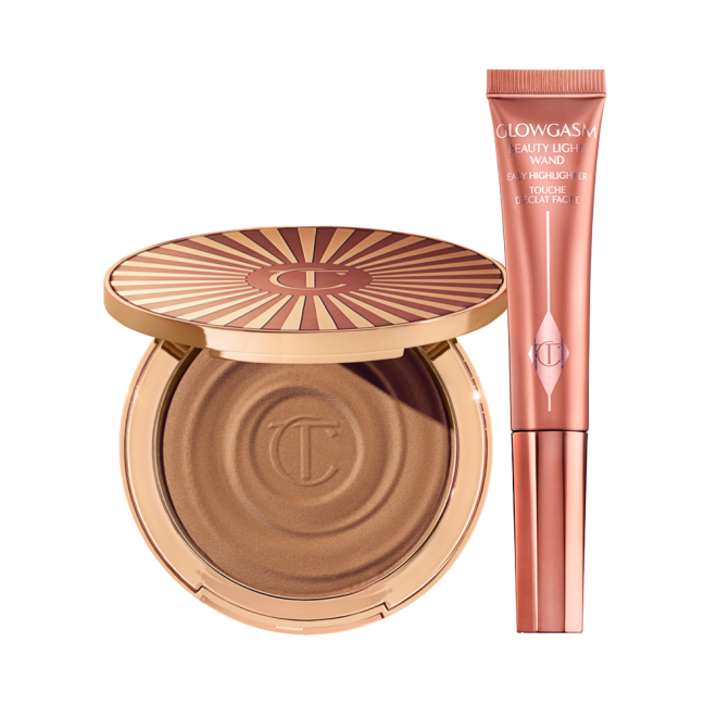 An open cream bronzer compact with gold-coloured packaging with a highlighter blush wand in a medium-pink colour in sleek, reflective, medium-pink colour packaging.