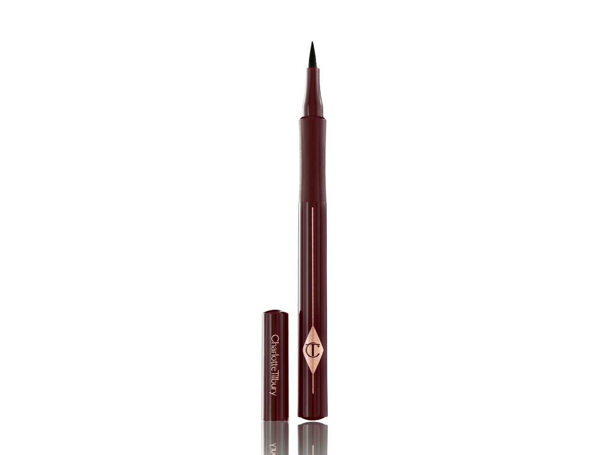 An eyeliner pen in a dark brown shade with dark crimson packaging with its cap next to it. 