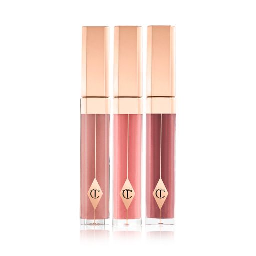 Three high-shine lip glosses in clear tubes with gold-coloured lids in mauve, bubblegum pink, and wine. 