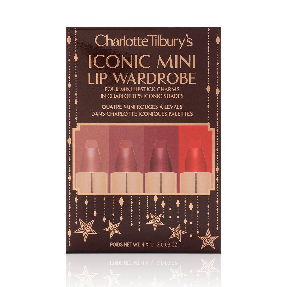 Five matte lipsticks in nude shades of red and pink in their dark-brown gift set box with text written on the front that reads, 'Charlotte Tilbury's Iconic mini lip wardrobe'.