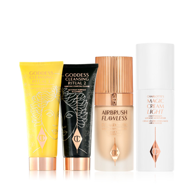 Two facial cleansers, one in lemon-yellow packaging and the other in charcoal-black, with rose-gold coloured lids, foundation in a frosted glass bottle with a gold-coloured lid, and light face cream in white-coloured packaging.