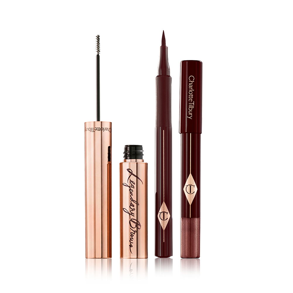 An open eyebrow tint in a gold-coloured tube, eyeliner pen in black, and chubby eyeshadow stick in a shimmery brown shade. 